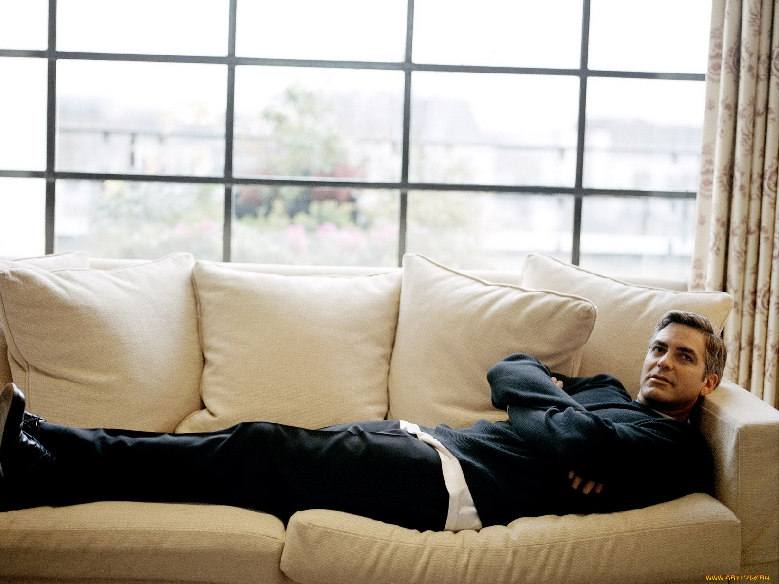 Фото лежащего мужчины. Джордж Клуни лежит на диване. Мужчина на диване. Парень лежит на диване. Мужская фотосессия на диване.